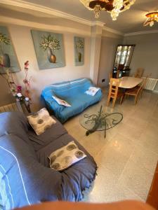 ein Wohnzimmer mit einem Bett und einem Tisch in der Unterkunft Appartement Spacieux proche commerces et plage Centre-Ville in Roses