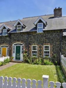 a brick house with a fence in front of it at Copperpot Cottage 5 mins to the beach! Autumn and Xmas stays booking now in Portrush