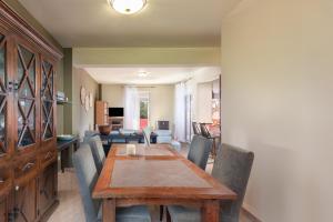 ein Esszimmer mit einem Holztisch und Stühlen in der Unterkunft Koralia Vacation House in Likotinaréa