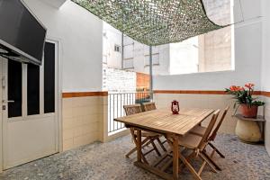 a dining room with a wooden table and chairs at Cal Guerrer in Mogente