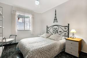 1 dormitorio blanco con 1 cama y 1 silla en Cal Guerrer, en Moixent (Mogente)