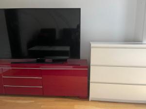 a red and white dresser with a flat screen tv at Roxi Oslo center in Oslo