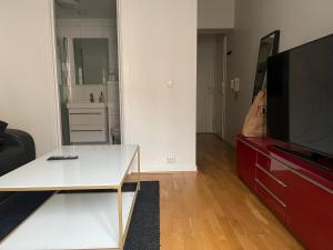 a living room with a white table and a tv at Roxi Oslo center in Oslo