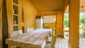 une salle à manger avec une table et des chaises dans une tente dans l'établissement Village Seasonova Bassin d'Arcachon, à Audenge