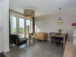 ein Wohnzimmer mit einem Tisch und einem Sofa in der Unterkunft Luxury apartment with sun shower at the edge of the beautiful Oostkapelle in Oostkapelle