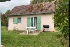 a small white house with green doors and a grill at MAISON Au LAC DU DER '' LES COCCINELLES 41 '' in Giffaumont-Champaubert