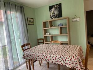 een eetkamer met een tafel en stoelen en een raam bij MAISON Au LAC DU DER '' LES COCCINELLES 41 '' in Giffaumont