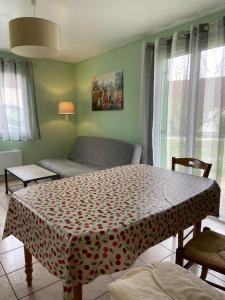 een woonkamer met een tafel en een bank bij MAISON Au LAC DU DER '' LES COCCINELLES 41 '' in Giffaumont