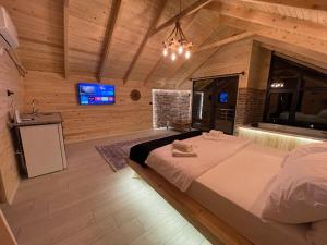 a bedroom with a large bed in a wooden room at Watersıde Bungalov in Çamlıhemşin