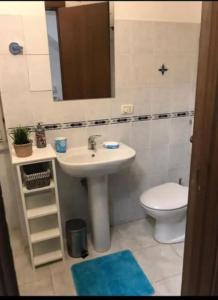 a bathroom with a sink and a toilet and a mirror at La Sardina 2.0 in Riomaggiore