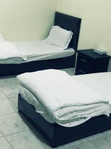 two beds sitting in a room with at دانية للأجنحة الفندقية in Al Jubayl