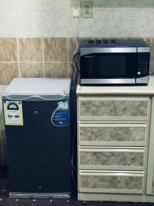 a microwave sitting on a counter next to a refrigerator at دانية للأجنحة الفندقية in Al Jubayl