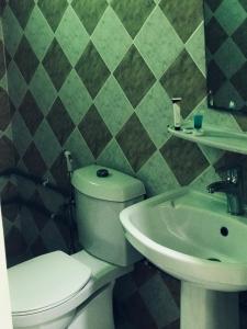 a bathroom with a toilet and a sink at دانية للأجنحة الفندقية in Al Jubayl