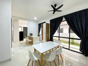 une salle à manger avec une table, des chaises et un ventilateur de plafond dans l'établissement BrandNew Modern Cozy House@ALMA NEAR JUSCO, à Bukit Mertajam