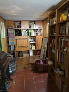 a living room with bookshelves and a room with a television at Villa di design nelle colline della Valsesia in Ghemme