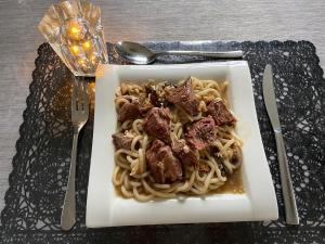 a plate of pasta with meat on a table at No Bathroom B&B in Aalten