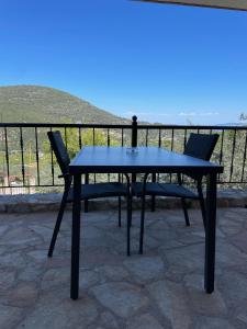 una mesa azul y 2 sillas en el patio en Orange Apartments, en Epáno Epídhavros