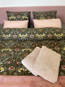 1 cama con colcha floral y 2 almohadas en Orange Apartments, en Epáno Epídhavros