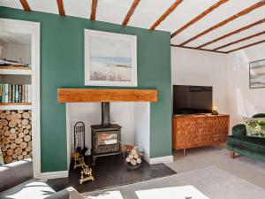 a living room with a fireplace and a tv at 3 Bed in Cemaes 92812 in Llanfechell