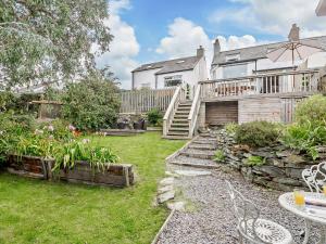 a backyard with a house and a garden with a stairway at 3 Bed in Cemaes 92812 in Llanfechell