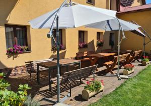 une terrasse avec un parasol, des tables et des bancs dans l'établissement Rezidence Lipka, à Králíky