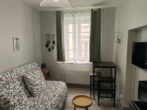a living room with a couch and a table and a window at Escale en Ardèche in Tournon-sur-Rhône