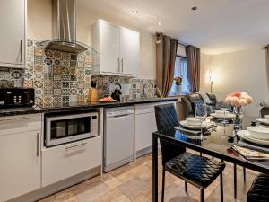 a kitchen with white cabinets and a table with chairs at 2 Bed in Apperknowle 94513 in Unstone