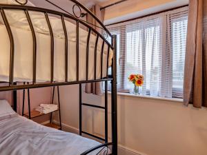 - une chambre avec des lits superposés et une fenêtre ornée d'un vase de fleurs dans l'établissement 2 Bed in Apperknowle 94513, à Unstone