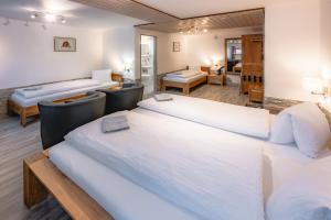 1 dormitorio con 2 camas y sala de estar en Hotel Paradis-Leukerbad-Therme en Leukerbad