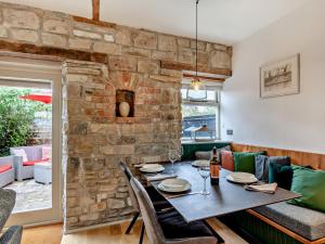 a dining room with a table and a stone wall at 2 Bed in Glastonbury 94480 in Shapwick