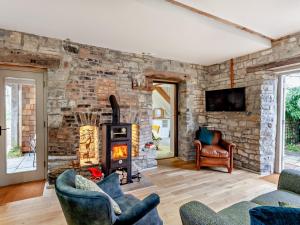 a living room with a stone wall and a wood stove at 2 Bed in Glastonbury 94480 in Shapwick