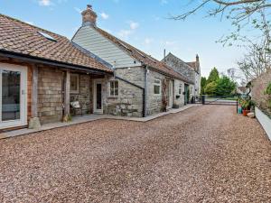 an old stone house with a gravel driveway at 2 Bed in Glastonbury 94480 in Shapwick