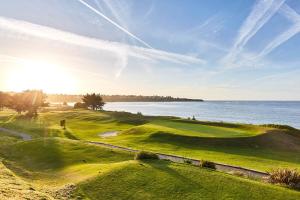 un campo de golf con el océano en el fondo en EMERAUDE en Saint-Cast-le-Guildo