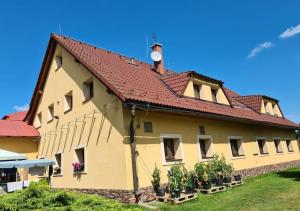 un grand bâtiment avec un toit rouge et quelques plantes dans l'établissement Rezidence Lipka, à Králíky