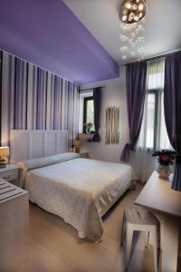 - une chambre avec un grand lit et des plafonds violets dans l'établissement Hotel Atlanta Augustus, sur le Lido de Venise