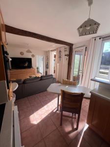 een woonkamer met een tafel en een bank bij Bessi - Maison de charme Trouville sur mer in Trouville-sur-Mer