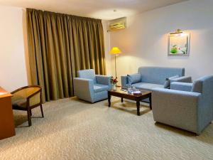 阿特勞的住宿－騰格里酒店，客厅配有两把椅子、一张沙发和一张桌子