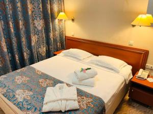 a hotel room with a bed with towels on it at Tengri Hotel in Atyraū