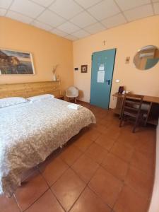 a bedroom with a bed and a desk and a table at Agriturismo Boschi in Reggiolo