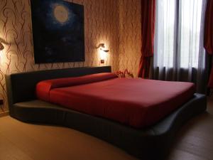 ein Schlafzimmer mit einem Bett mit einer roten Decke darauf in der Unterkunft Hotel Atlanta Augustus in Lido di Venezia