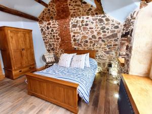 a bedroom with a bed and a stone wall at 1 Bed in Ravenglass 94503 in Ravenglass