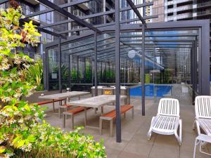 a patio with tables and chairs in a building at The Southbank Central Retreat in Melbourne