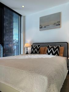 a bedroom with a large bed with a window at The Southbank Central Retreat in Melbourne