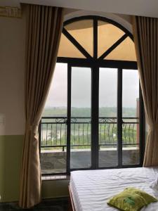 sypialnia z łóżkiem i dużym oknem w obiekcie Hồng Ngọc 1 Hotel Tà Đùng w mieście Biđong