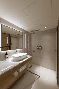 a bathroom with a sink and a shower at Radisson Hotel Graz in Graz