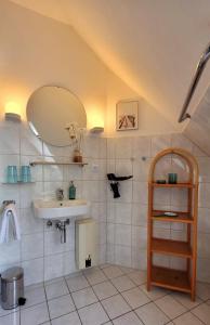 La salle de bains est pourvue d'un lavabo et d'un miroir. dans l'établissement Neujellingsdorf "Meer Natur Blick", à Westfehmarn