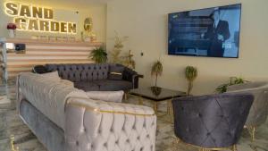 sala de estar con sofás y TV de pantalla plana. en Sand Garden Hotel Bodrum en Bodrum