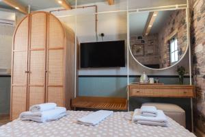 a bedroom with a bed with a mirror and a tv at Qara Otel in Ayvalık +64 photos