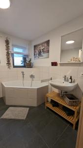 y baño con bañera y lavamanos. en Ferienwohnung im Zenngrund en Neuhof an der Zenn