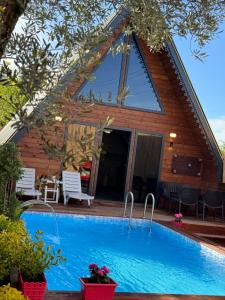 a house with a swimming pool in front of it at Maşukiye pink house bungalow in Kartepe